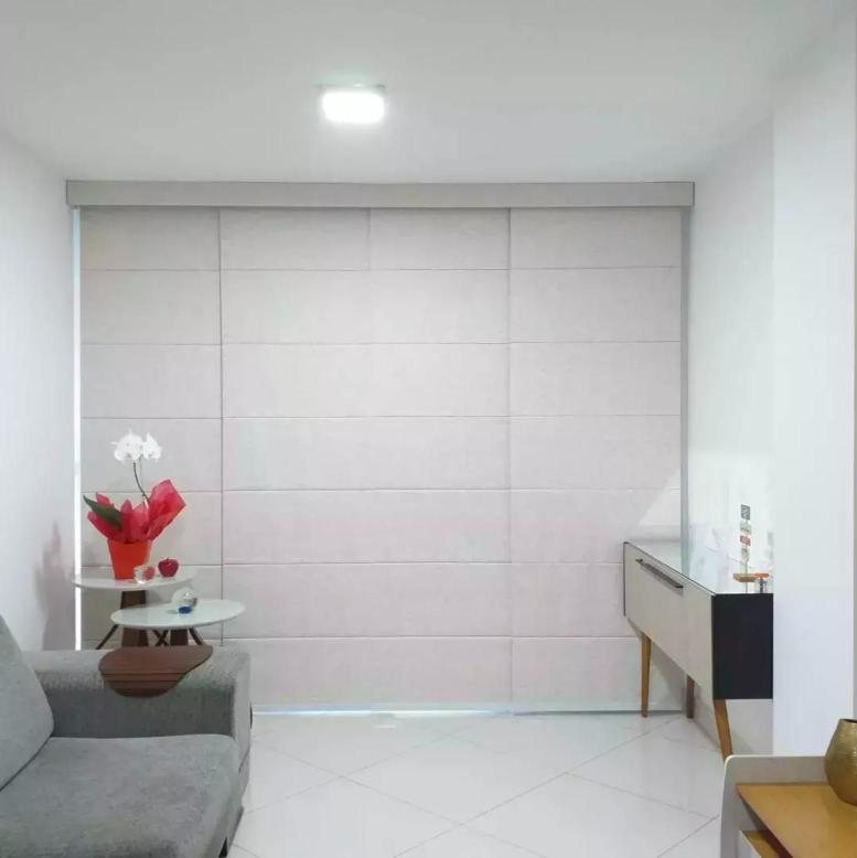 Persiana romana clara cobrindo a janela da sala